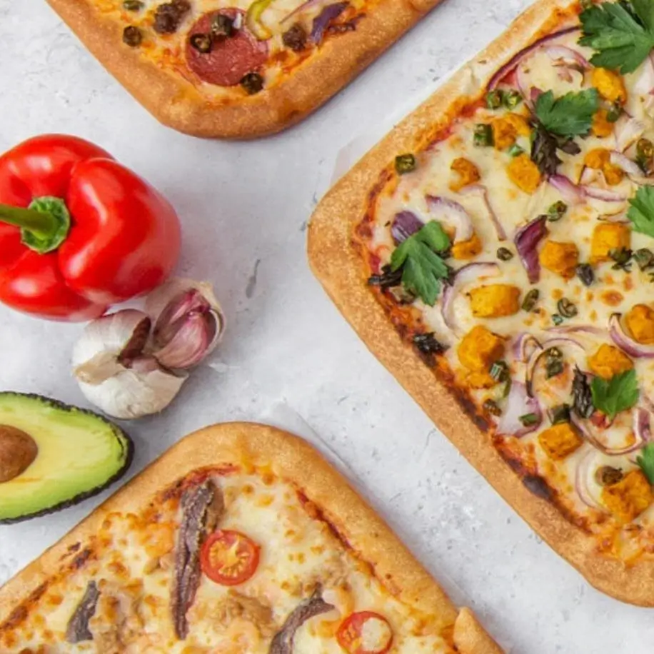 Square pizza and pizza ingredients on a table